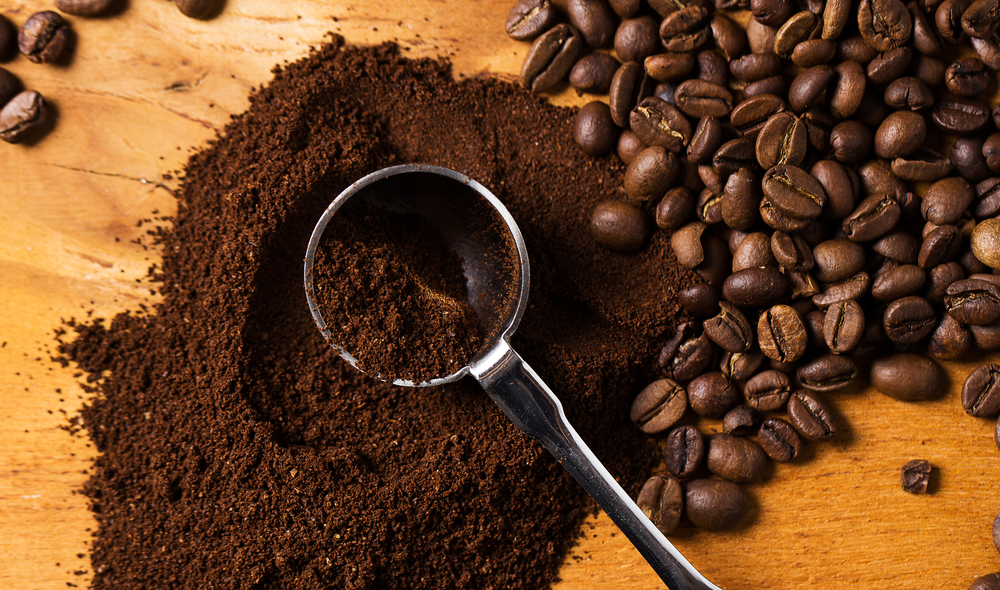 Coffee beans and ground coffee on a bench