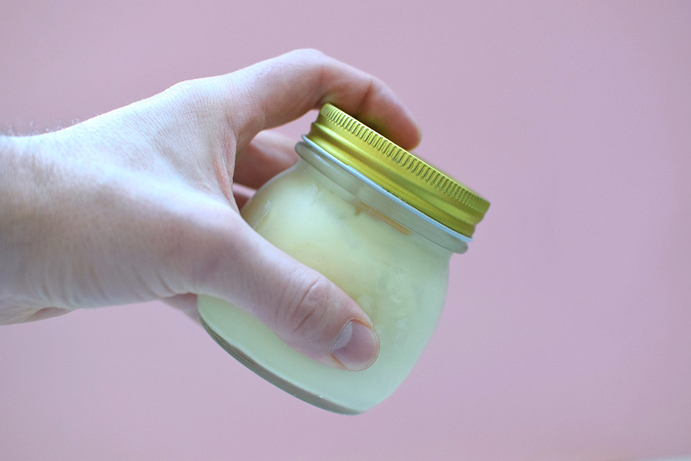 A hand holding a mason jar full of ice cream.