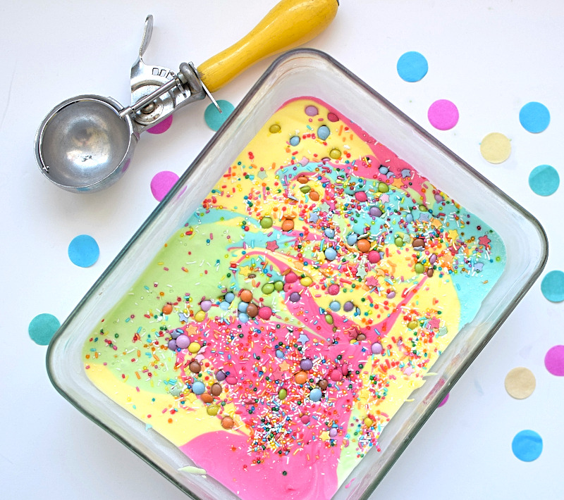 Rainbow ice cream with scoop next to it