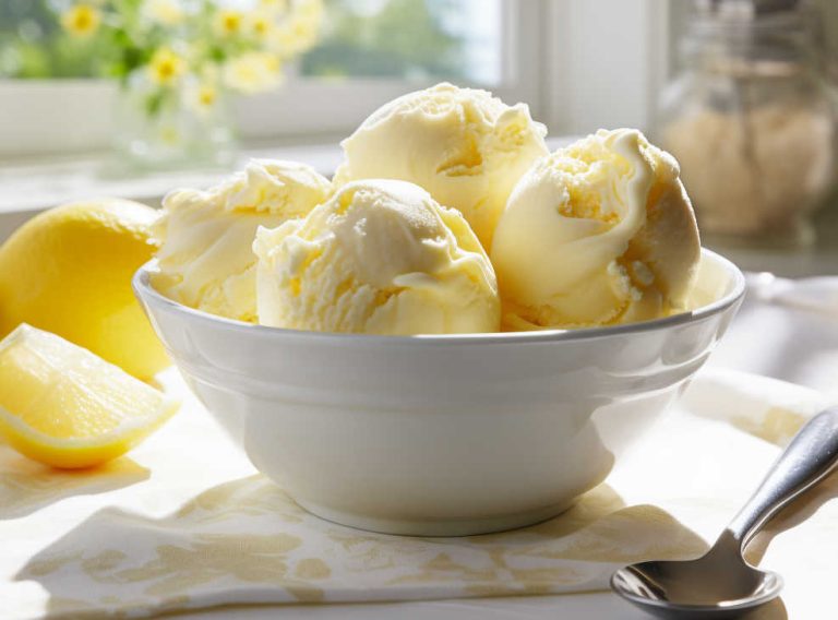 Scoops of homemade lemon ice cream in a bowl.