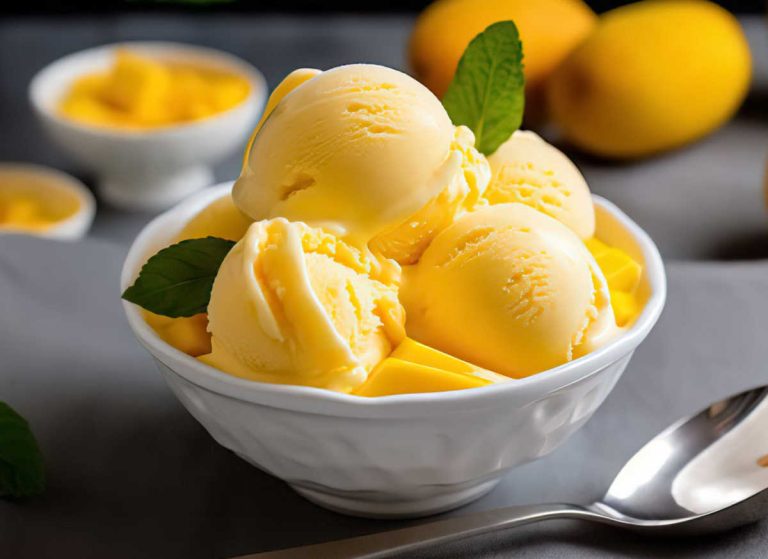 Scoops of homemade mango ice cream in a white bowl.