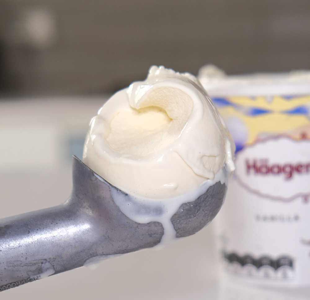 A scoop of Haagen-Dazs ice cream with the kitchen countertop in the background.