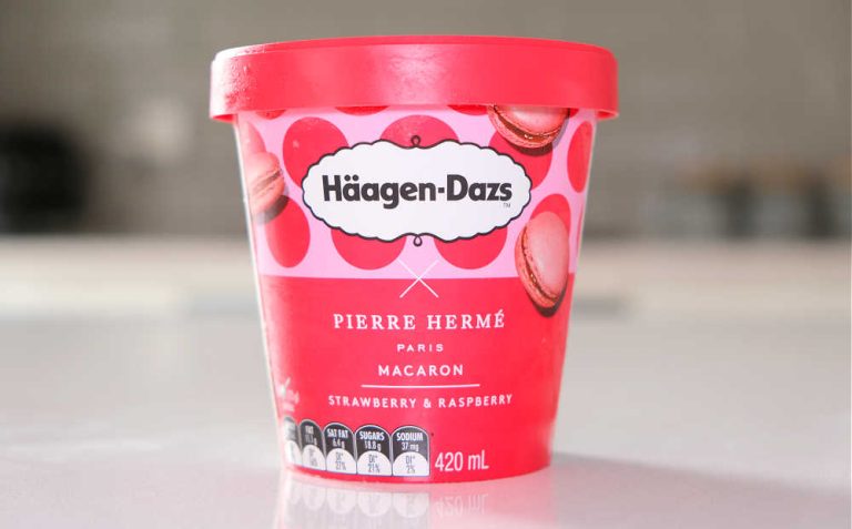 A front-on image of a tub of Haagen-Dazs Macaron Strawberry and Raspberry Ice Cream on a kitchen countertop