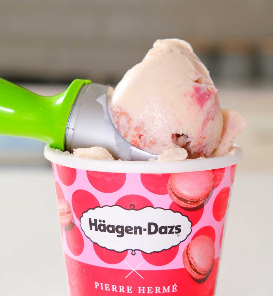 A scoop of Haagen Dazs Macaron Strawberries & Raspberries icecream sitting on the open tub.