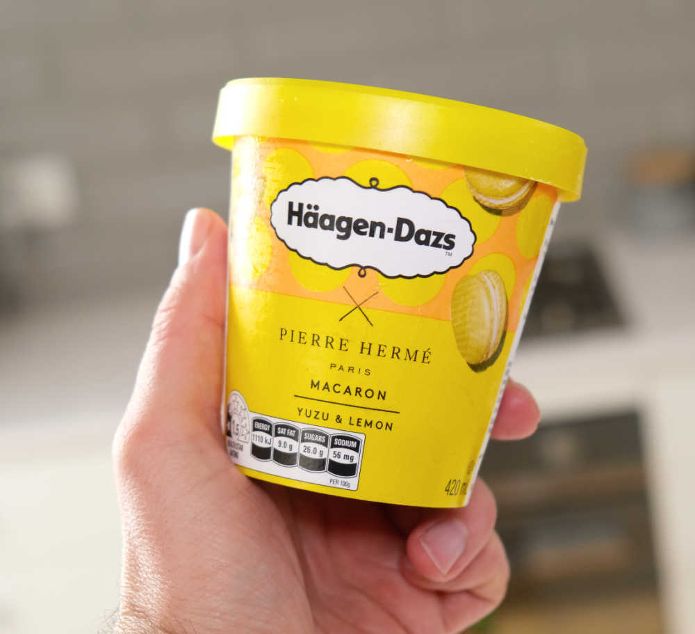 A hand grasping a pint of Haagen-Dazs Yuzu and Lemon Ice Cream