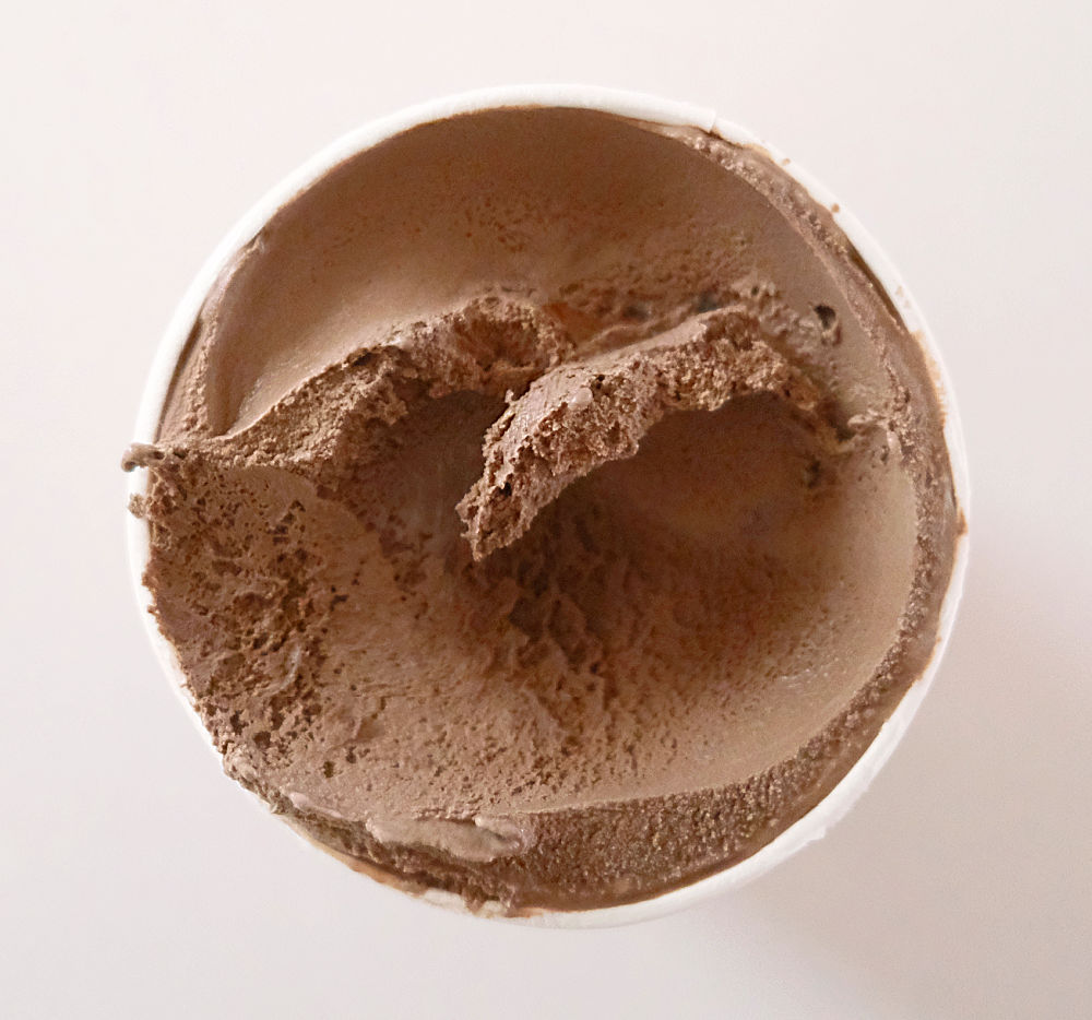 A top down pic of the Bulla Murray St Chocolate Fudge Ripple Ice Cream with some of the contents scooped out.