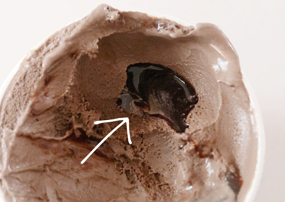 A zoomed in photograph highlighting a pol of runny fudge ripple.