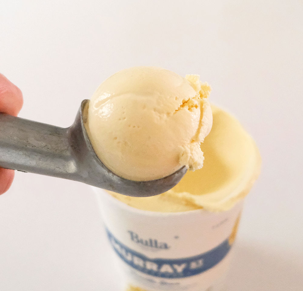 Closeup image of a scoop full of ice cream and the pack in the background
