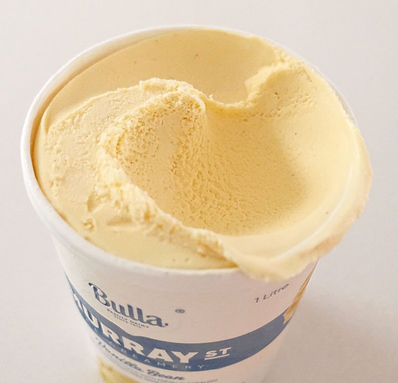 An angled top-down image of ice cream with a big scoop removed