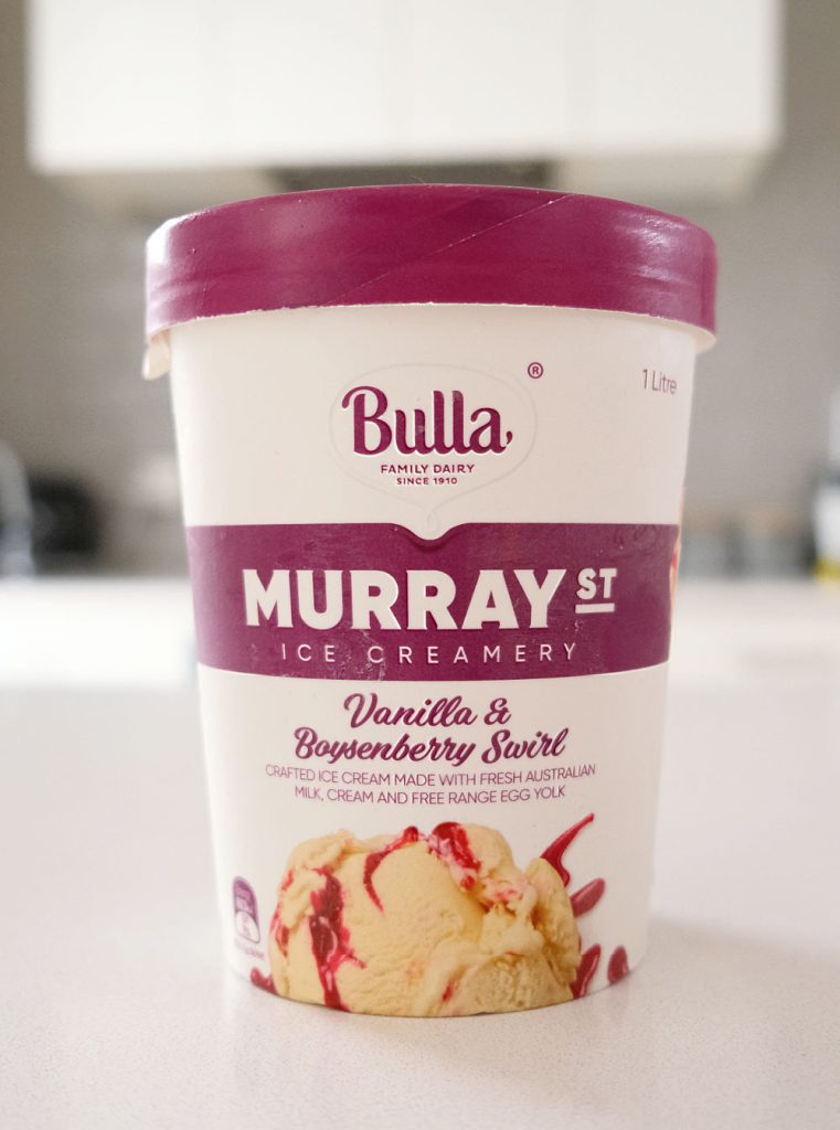 A vertical closeup of Murray St Vanilla Boysenberry Ice Cream on a kitchen countertop.