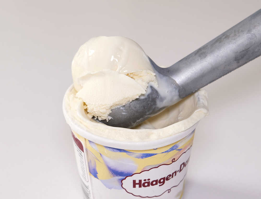 Macro image of a large scoop of vanilla ice cream resting in the tub.