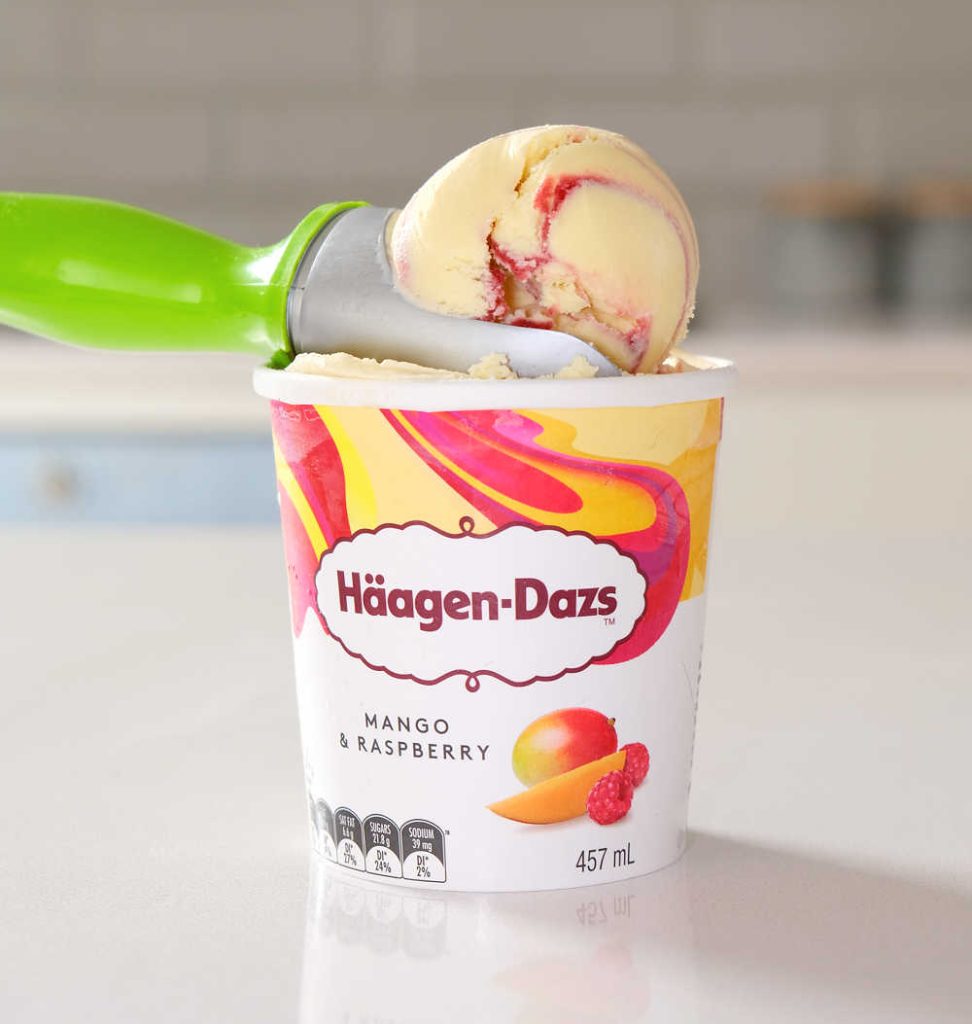 An ice cream scoop with a large ball of Mango and Strawberry ice cream.
