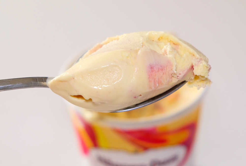 A macro spoonful of Haagen-Dazs Mango Raspberry showing its creamy texture.