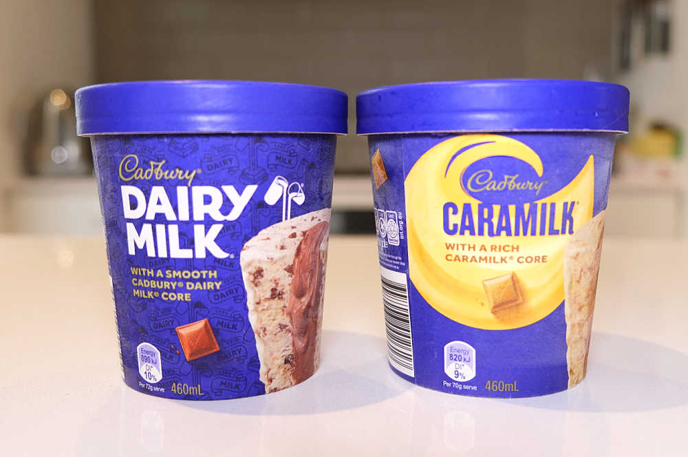 Tubs of Caramilk and Dairy Milk ice cream on a countertop.
