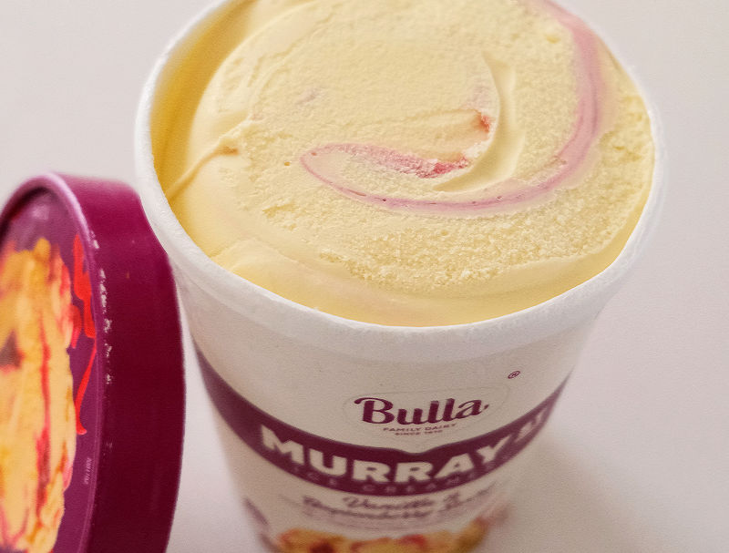 The opened container of vanilla and boysenberry ice cream.