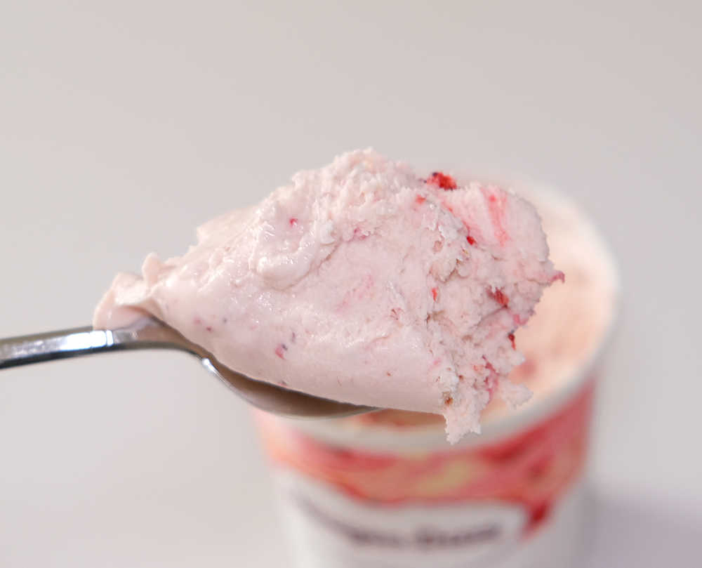 Macro photograph of HD Strawberries and Cream Ice Cream on a spoon.