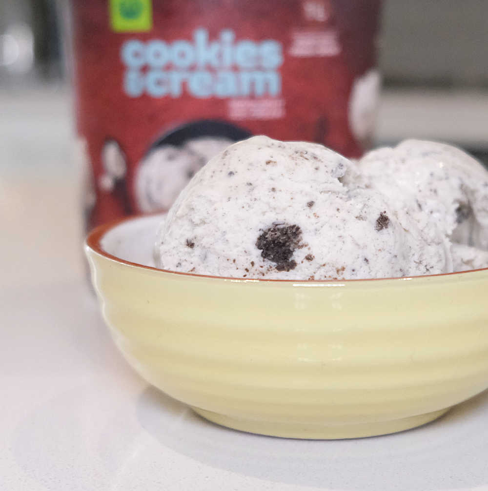 A bowl of WOW Cookies and Cream with the ice cream pack in the background.