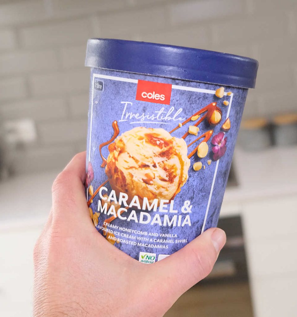 Holding a tub of Caramel Macadamia Ice Cream by Coles.