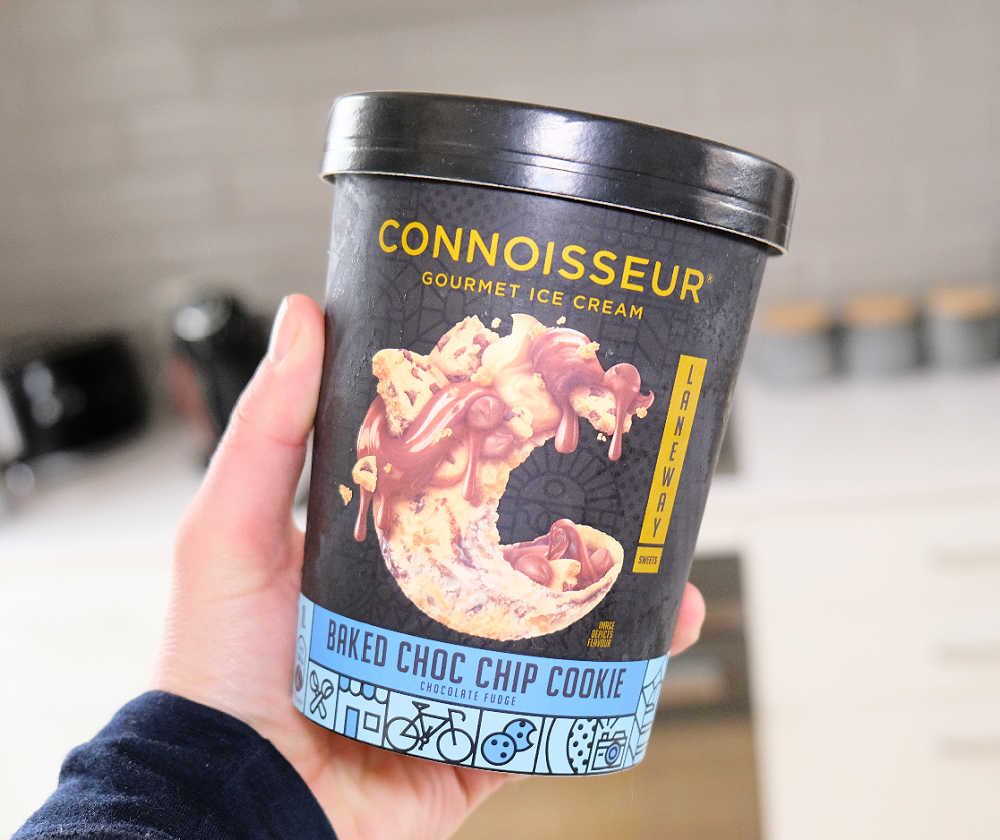 A hand holding a pack of Connoisseur Laneway Choc Chip Cookie Ice Cream.