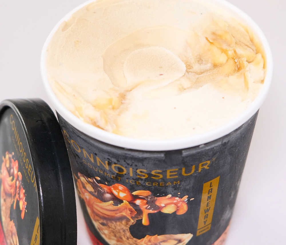 An image of an opened tub of Connoisseur Crunchy Peanut Butter Ice cream that hasn't been scooped.