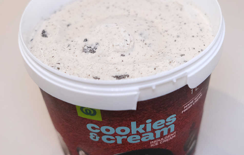 An unscooped tub of Cookies and Cream Ice Cream 1L by Woolworths.