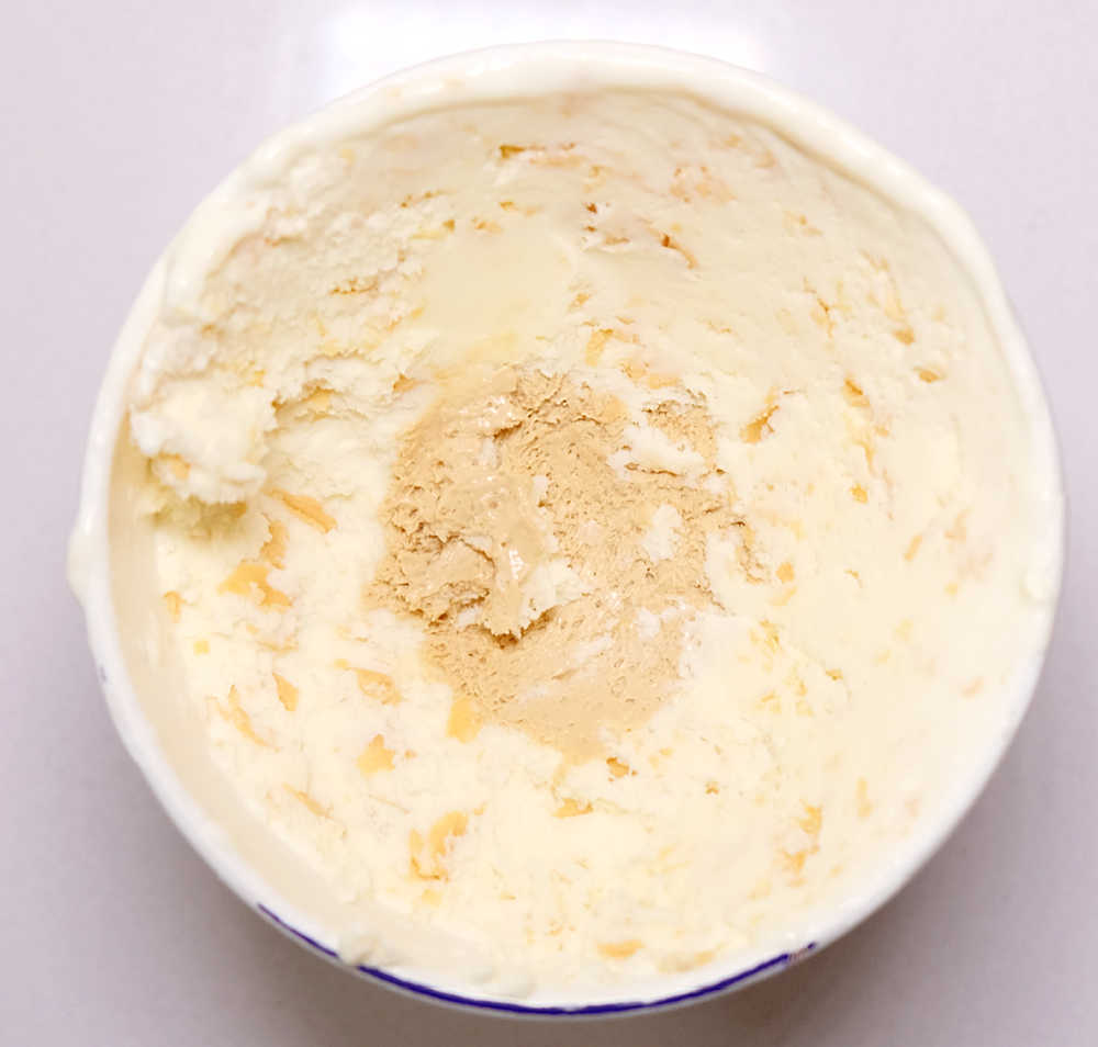 Bird's eye photograph of a partially eaten container of Cadbury Caramilk ice confection.
