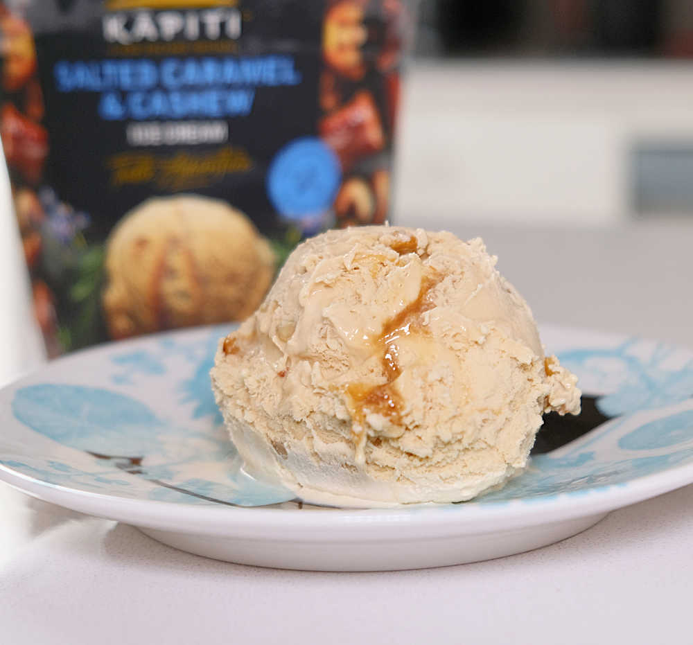 A dish with a scoop of Kapiti Salted Caramel and Cashew with the pack in the background.