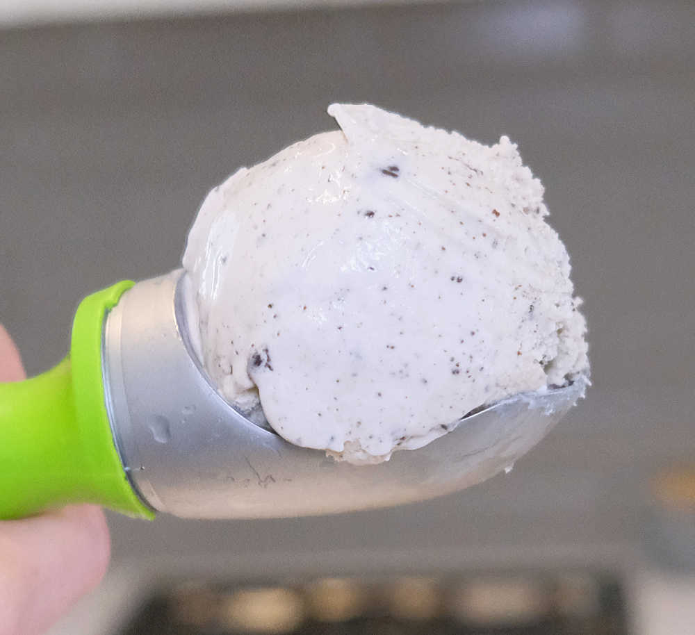 A scoop of C&C Ice Cream with a blurry kitchen in the background.