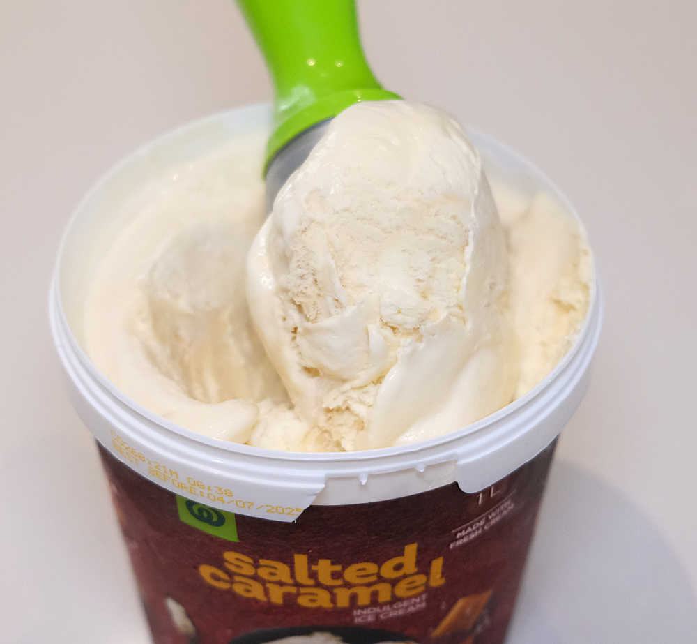 Closeup of a scoop of Woolworths Salted Caramel Ice Cream 1L.