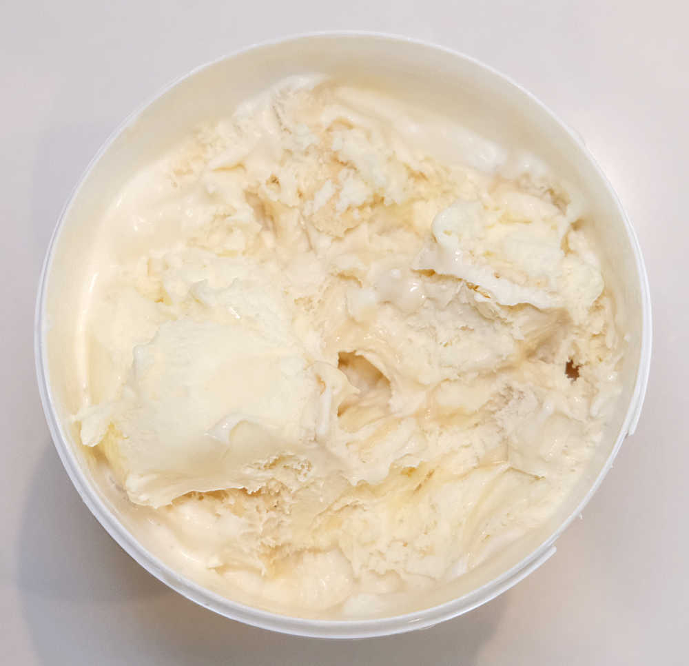 Top-down shot of a partly eaten tub of Salted Caramel Ice Cream by Woolworths.