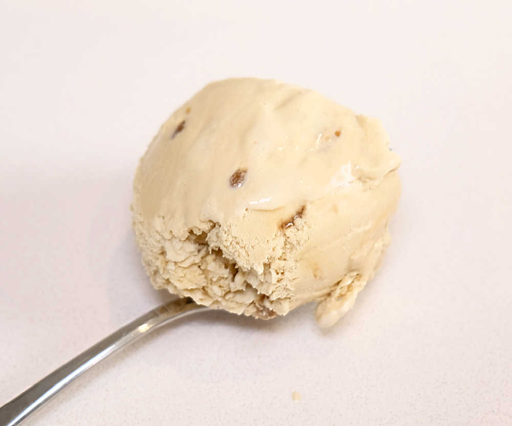 A spoonful of Much Moore Salted Caramel Ice Cream on a white bench.
