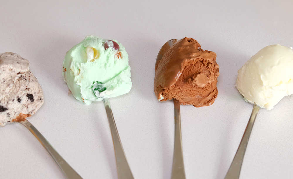 Four spoons with scoops of each flavour from the Much Moore Family Classic Ice Cream tub.