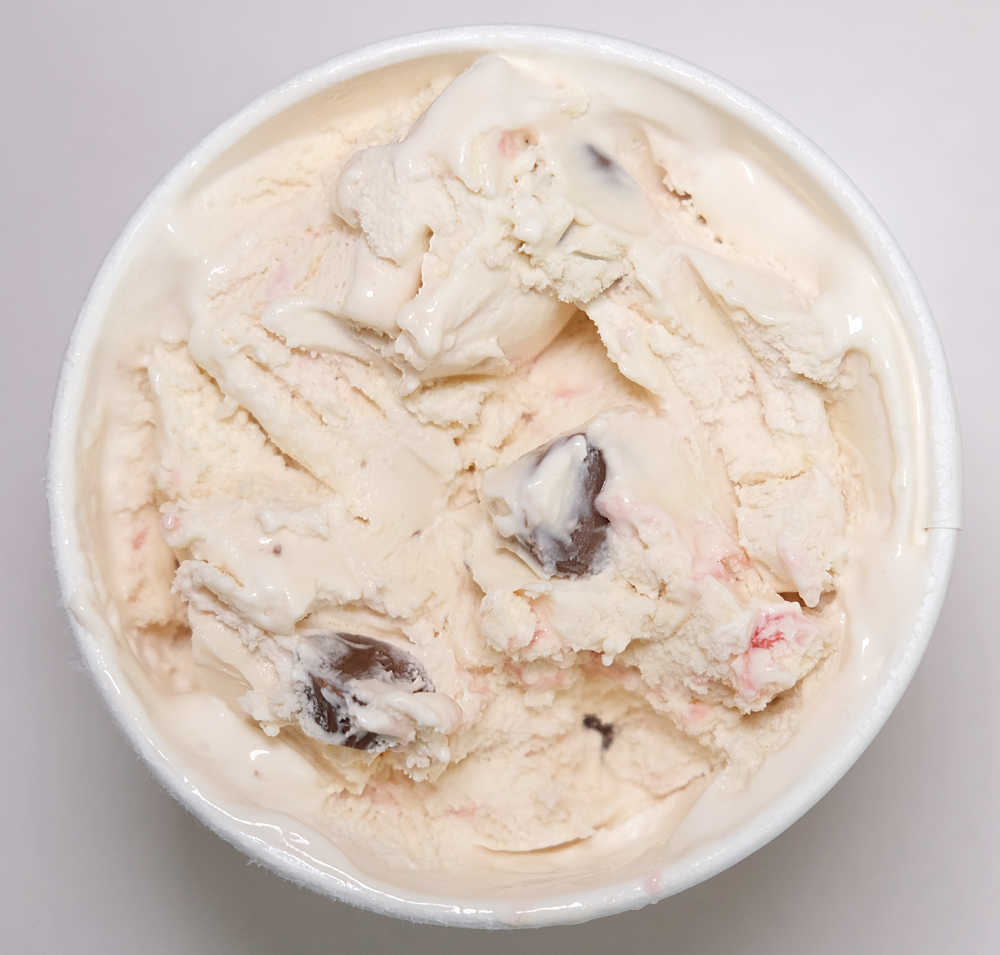 Top down photo showing partly eaten container of Peanut Butter Cup Raspberry Ripple Ice Cream by Woolworths.