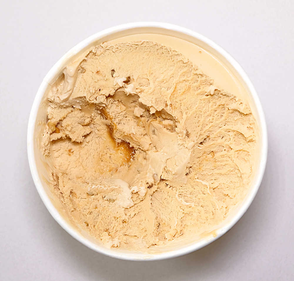A partially eaten tub of Kapiti Salted Caramel and Cashew Ice Cream.