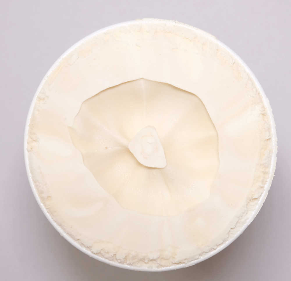 A top-down shot of a container of un-scooped Coles Irresistible Salted Caramel Ice Cream 1L.