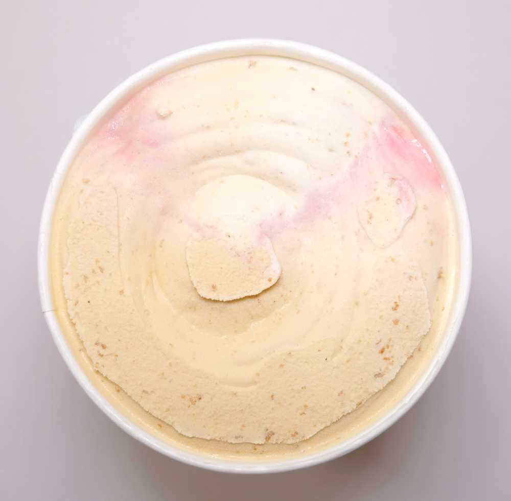 A top-down photo of an opened tub of Connoisseur Jam Doughnut Ice Cream.