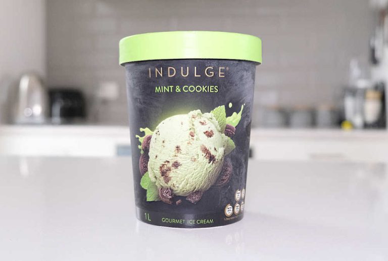 A tub of Indulge Mint and Cookies Ice Cream on a kitchen bench.