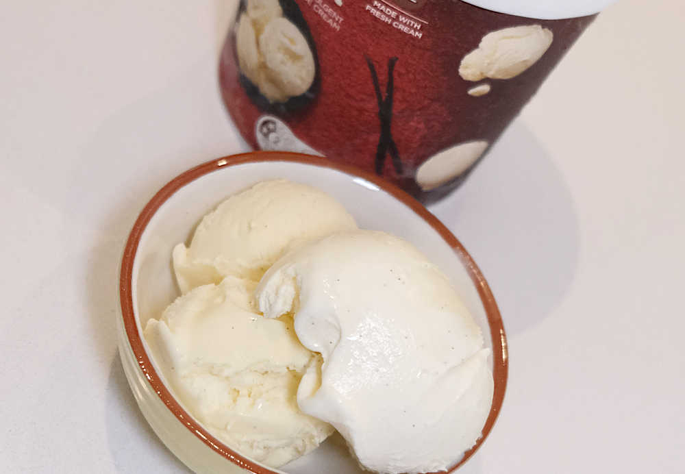 Softened scoops of ice cream in a bowl next to the pack.