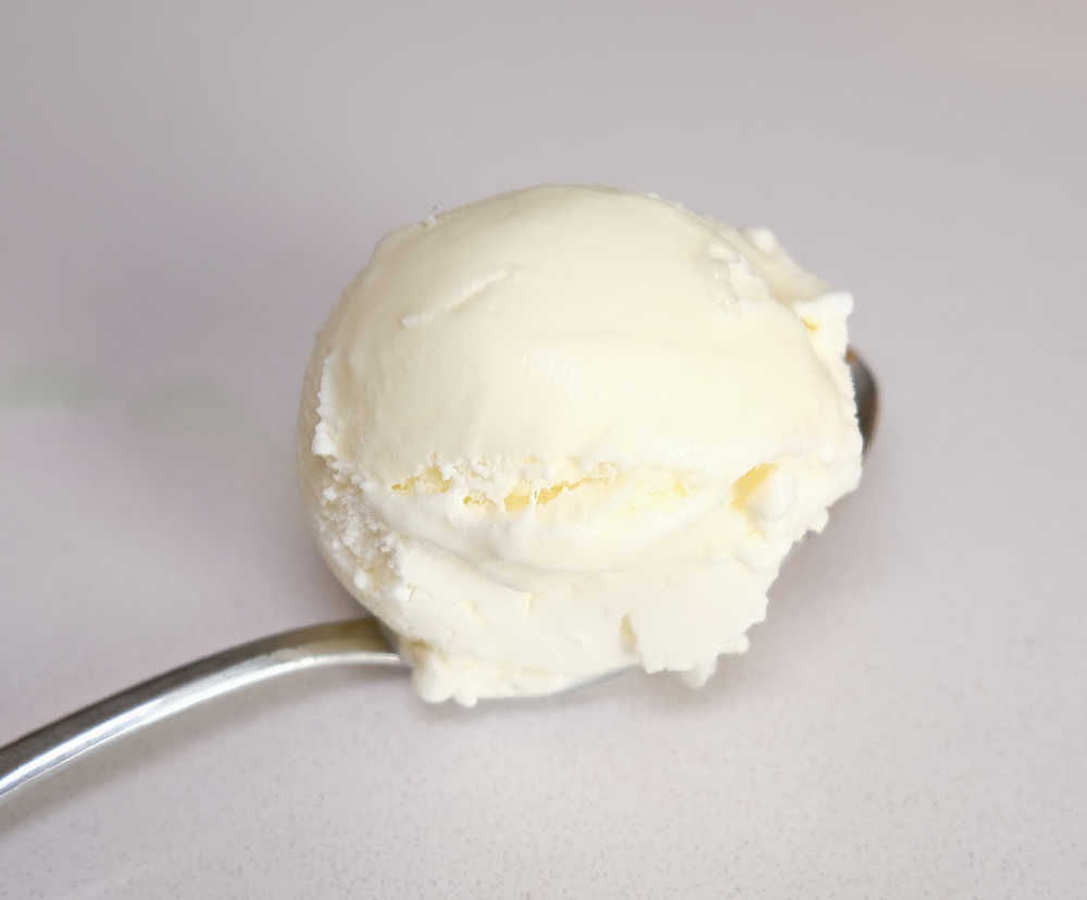 Closeup of a spoonful of vanilla ice cream from a pack of Much Moore Family Classic.