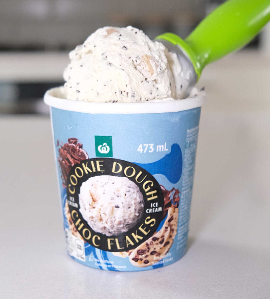 A scoop full of ice cream leaning on the top of the pack.
