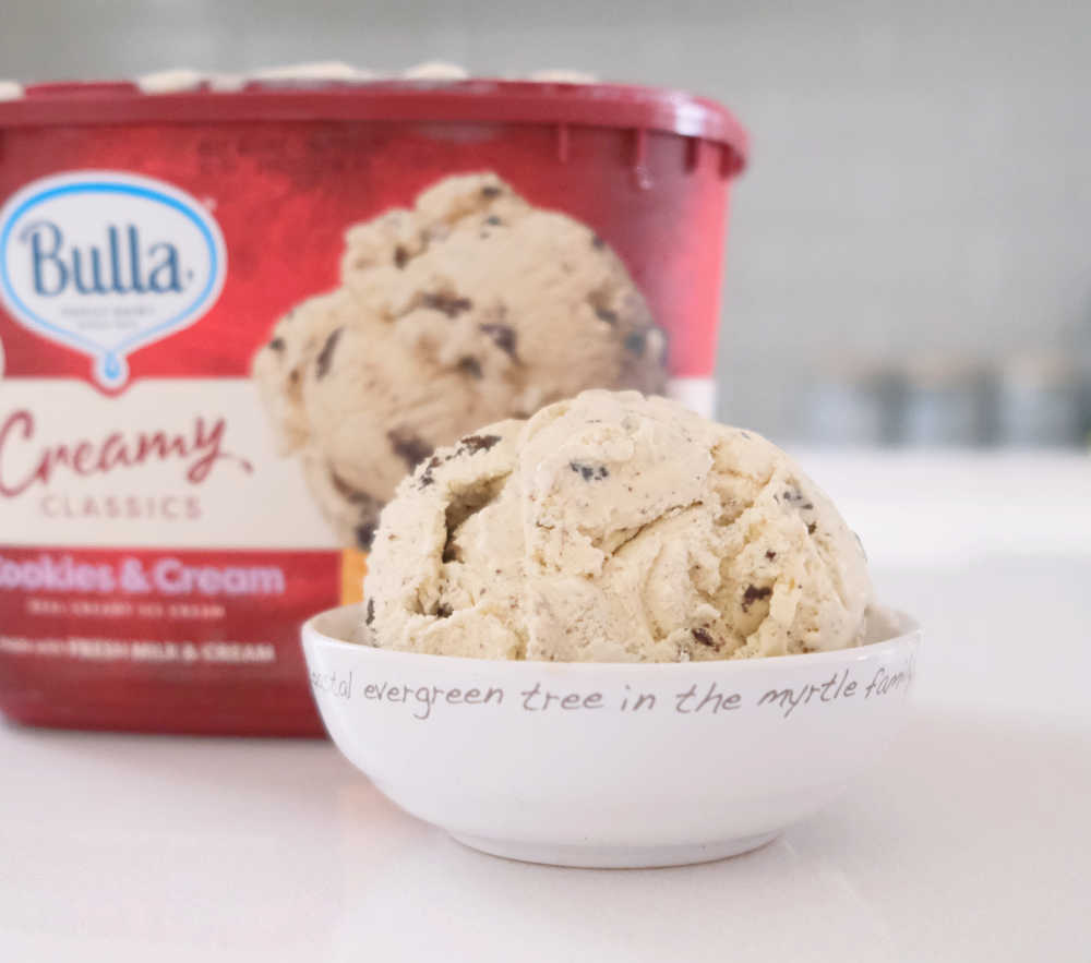 A bowl of Creamy Classics Cookies and Cream with the pack in the background.