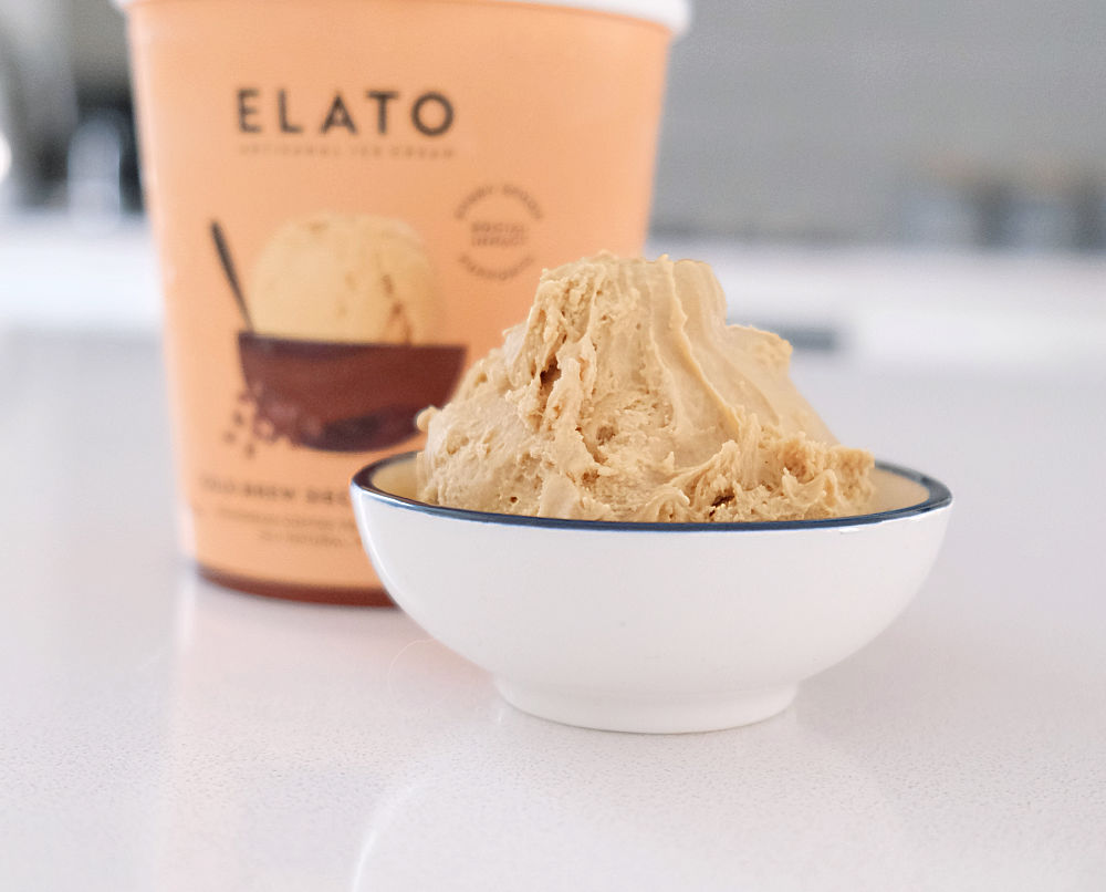 A bowl of Elato Cold Brew Decaf Cafe Latte with the pack in the background.