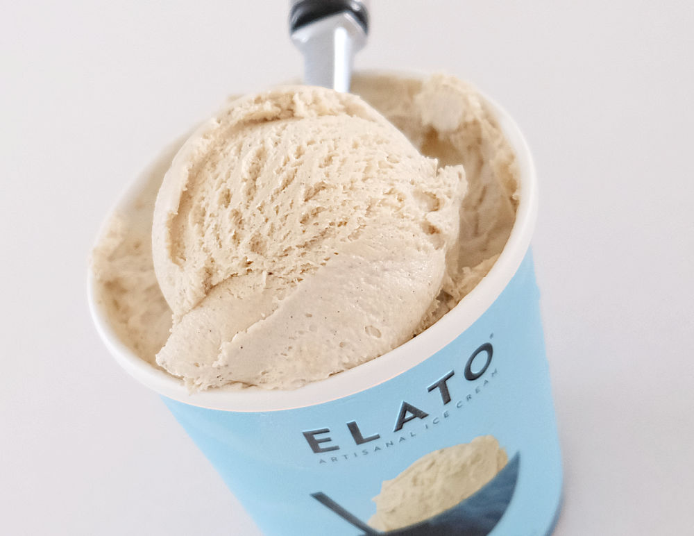A scoop of Elato Triple Vanilla Ice Cream resting on the top of the 475ml container.