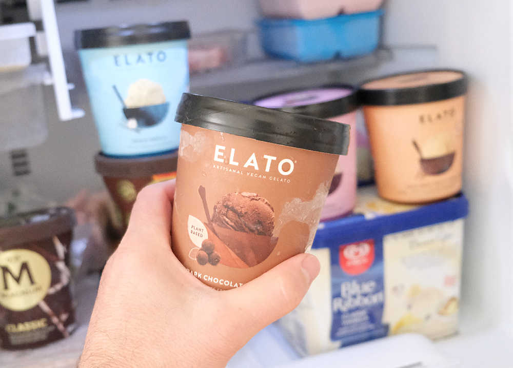 Holding a pack of Elato Vegan Dark Chocolate Truffle Gelato.