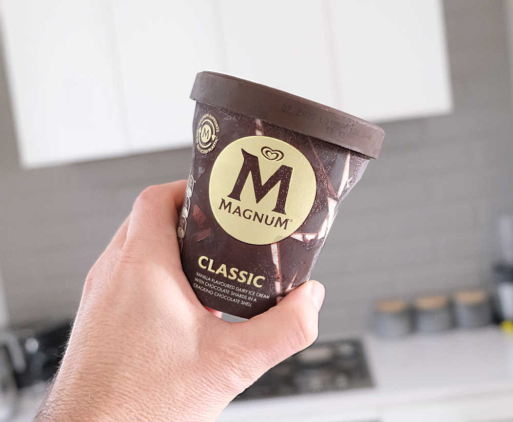 A hand holding a pack of Magnum Classic 440ml.