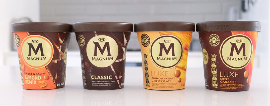 A line of Magnum ice cream tubs on a kitchen bench.