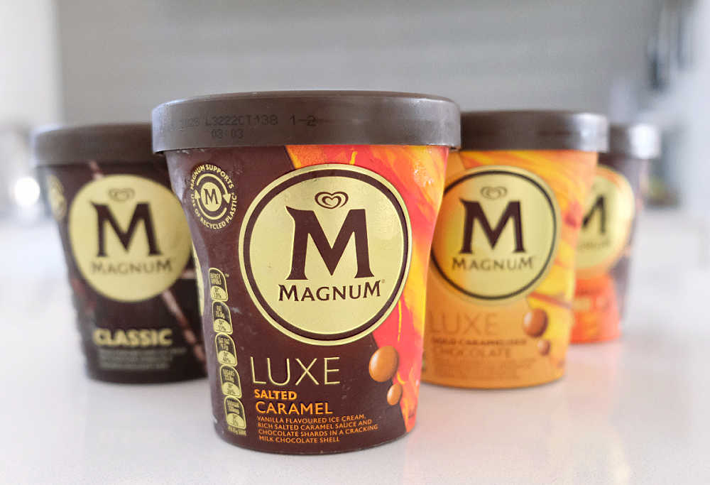 A group of Magnum ice cream tubs with the Luxe Salted Caramel variant at the front.