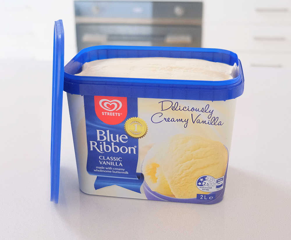 An unscooped pack of Blue Ribbon Creamy Vanilla with the lid resting on the side.