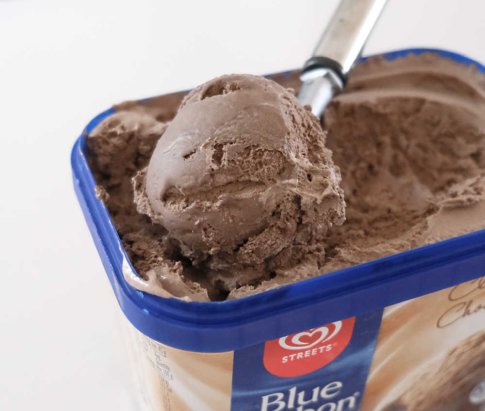 A scoop of Streets Blue Ribbon Chocolate Ice Cream resting on the top of the pack.