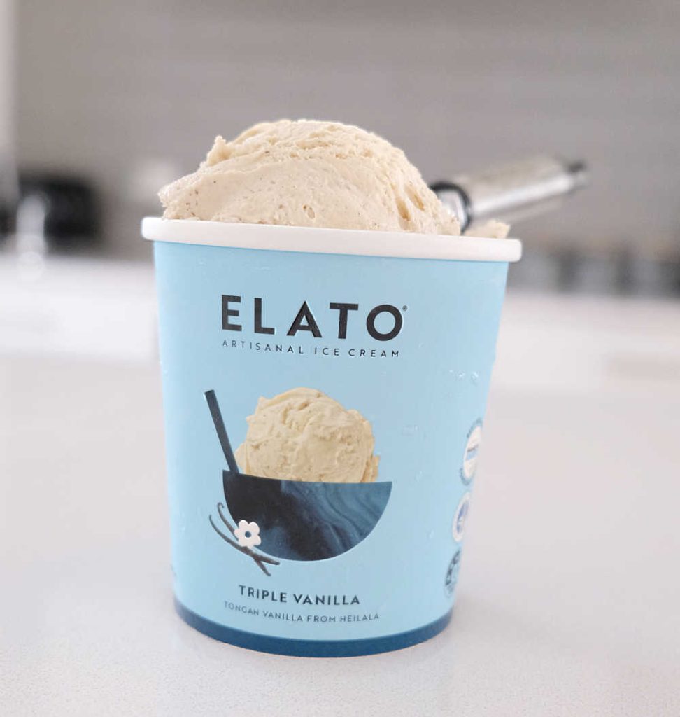 A scoop of Elato Triple Vanilla Artisinal Ice Cream with a scoop resting on the top of the pack.